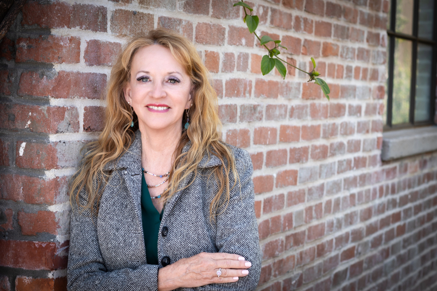 DeAnn Oliver, RN, standing in front of a brick wall